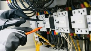 Electrician testing an electrical panel with a multimeter
